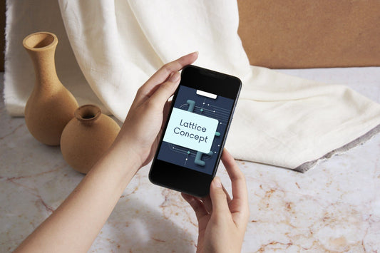 A person holds a smartphone showing a digital design template with the text 'Lattice Concept' on the screen, set against a styled background of terracotta vases, draped cream fabric, and a marble surface.